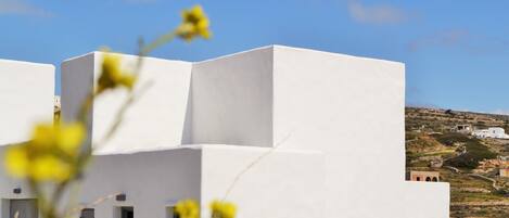 Un bâtiment blanc avec un toit plat et une petite fenêtre.