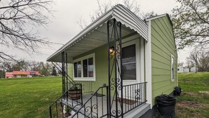 A small, single-story house with a porch, a front door, and a window. - Sleek and Central Small Home ~ Close to everything (Flint)