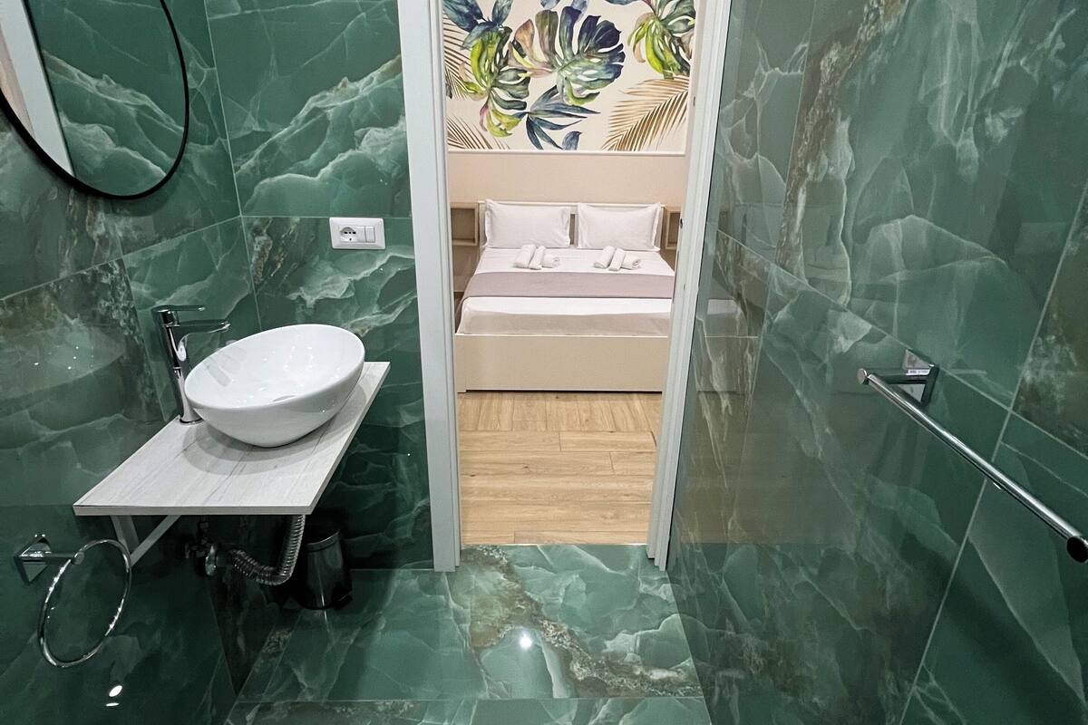 A bathroom with a sink, bidet, and a mirror.