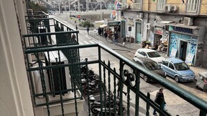 Un balcón con vista a una calle, scooters estacionados y un edificio con un cartel que dice 'LAVASFUGA'.