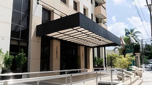 A modern building with a covered entrance, a staircase, and a metal railing.
