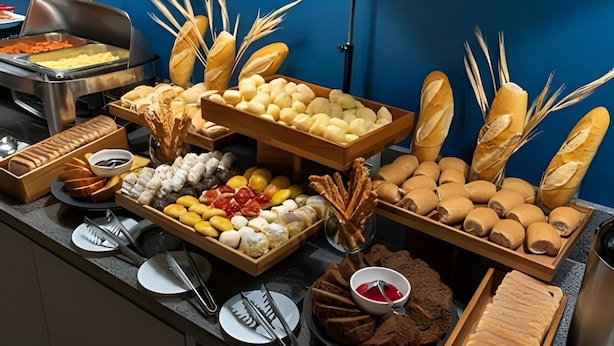 A buffet with various breads, pastries, and desserts.