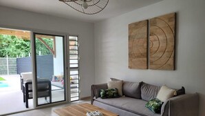 Una sala de estar con sofá, mesa de centro y una obra de arte en la pared.