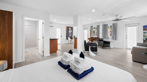 A spacious hotel room with a large bed, a desk, and a seating area. - Spacious Suite at New Yorker Hotel - Pool, Free Parking, WiFi and Coffee! (Miami)