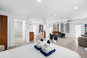 Une chambre d’hôtel spacieuse, dotée d’un grand lit, d’un bureau et d’un coin salon.