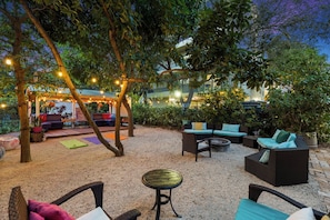 An outdoor patio area with seating arrangements, string lights, and a covered seating area. - Spacious Suite at New Yorker Hotel - Pool, Free Parking, WiFi and Coffee! (Miami)