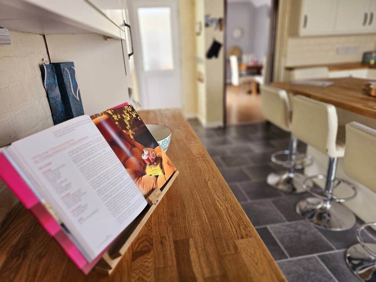 Una cocina con encimera de madera, un libro y una revista.