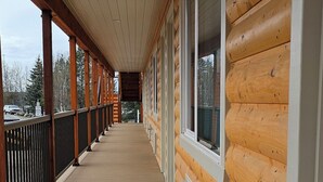A wooden cabin with a covered porch, large windows, and a view of the surrounding landscape. - Eagle River Lodge (Eagle River)