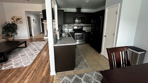 A modern kitchen with dark cabinets, stainless steel appliances, and a granite countertop. - 3 bedroom 2 bathroom home in heart of Buda, TX. (Buda)