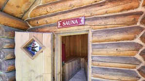 Eine Holzsauna mit einem Schild über der Tür und einem kleinen Fenster.