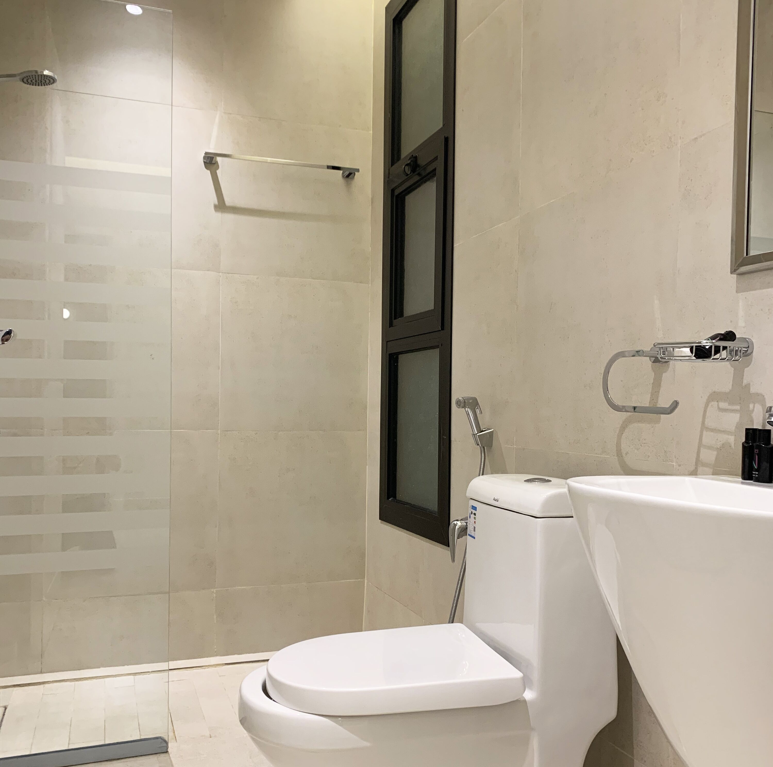 Ein modernes Badezimmer mit Toilette, Waschbecken und Dusche.