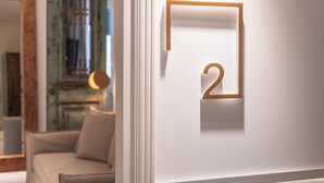A minimalist wall design with a geometric number '2' and a framed picture. - Silo Luxury Rooms Nafplio (Argos - Mykines)