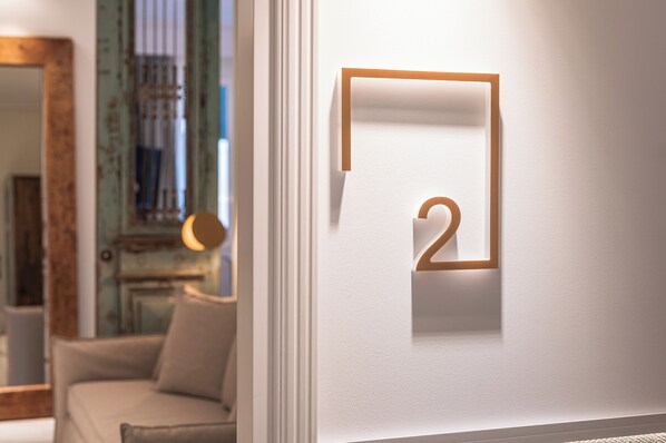 Un design minimaliste pour un mur, avec un chiffre « 2 » de forme géométrique et un tableau encadré.