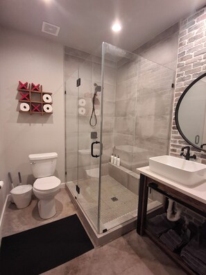 A modern bathroom with a glass-enclosed shower, a white sink, and a toilet. - Play Hard, Rest Easy. Comfortable Home Near Rocker B (Graford)