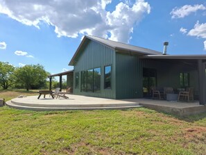 A green building with a covered patio area, large windows, and a chimney. - Play Hard, Rest Easy. Comfortable Home Near Rocker B (Graford)