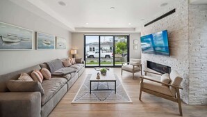 Ein modernes Wohnzimmer mit einer Couch, einem Couchtisch und einem Kamin.