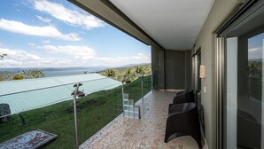 Ein Balkon mit Blick auf eine grüne Landschaft und ein Gewässer.