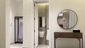 Ein modernes Badezimmer mit Waschbecken, Spiegel und Holzkommode.