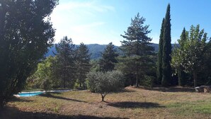 A pool surrounded by trees and a grassy area. - Luberon - Vue Exceptionnelle - Location de Maisonnette 4 Personnes (Ménerbes)