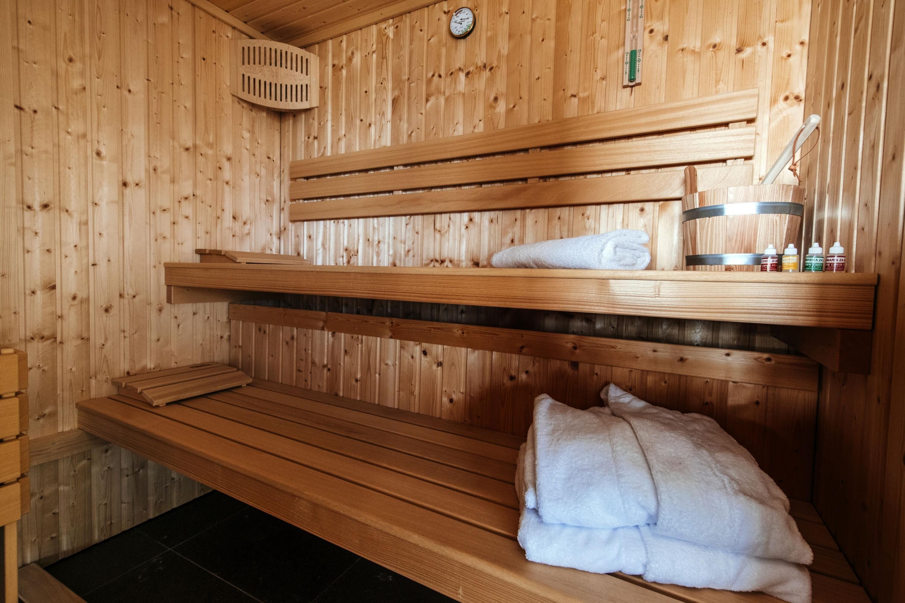 A wooden sauna with benches and a towel.