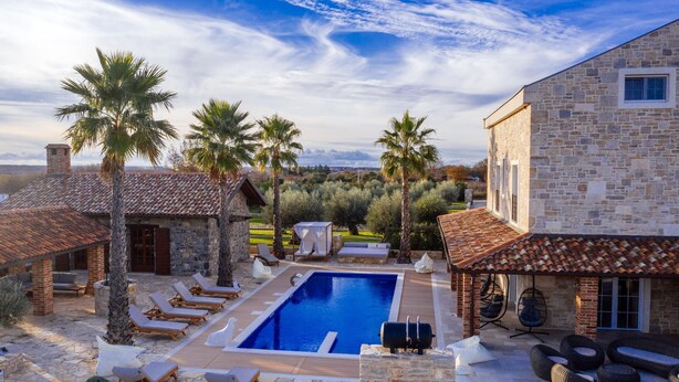A pool area with lounge chairs, a barbecue, and a stone building with a tiled roof. - Villa Marta Zadarvillas (Nin)