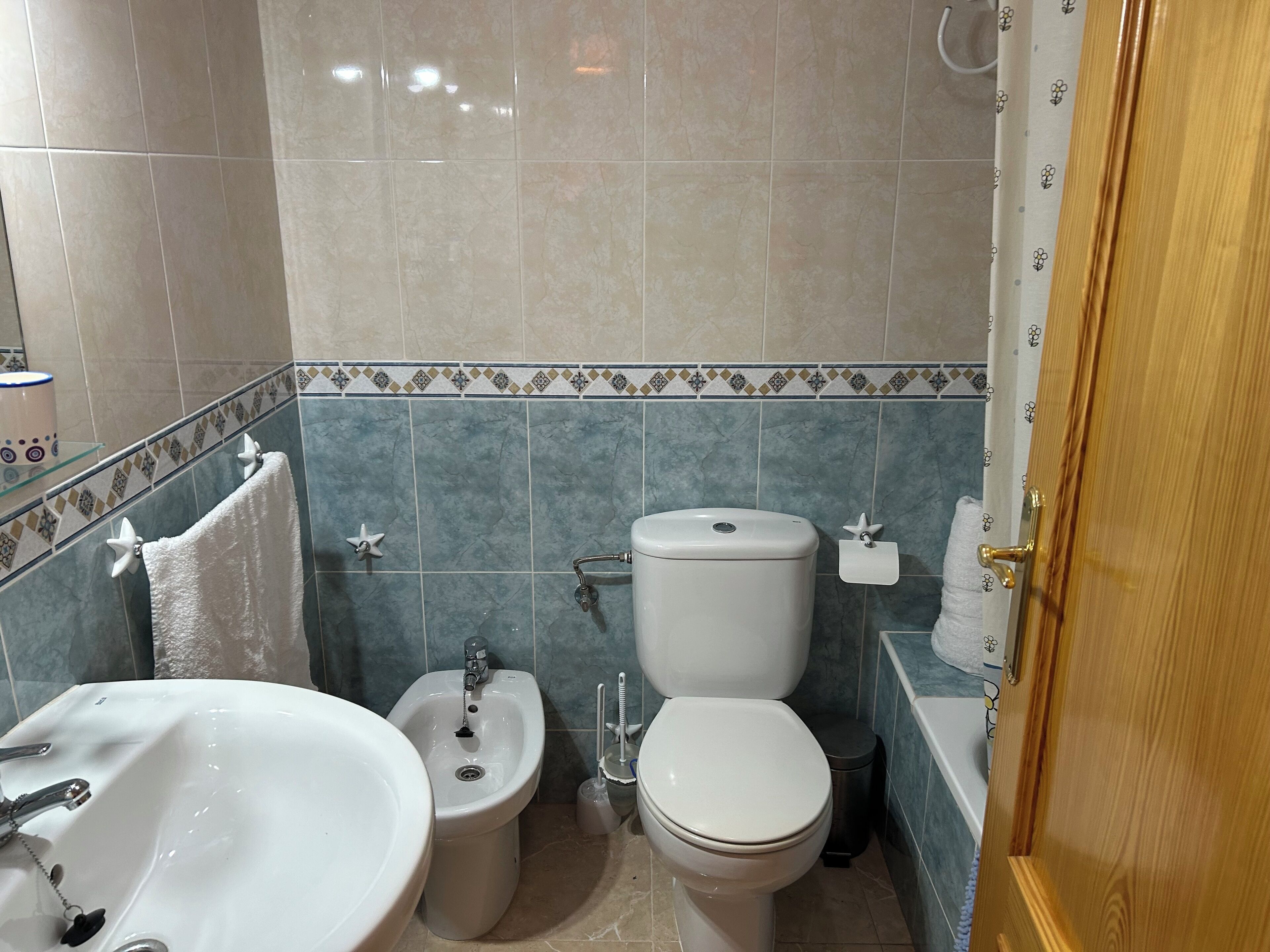 Casa de banho com lavatório, bidé, sanita e banheira.
