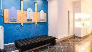 Una habitación con una pared azul, un banco de madera y una puerta blanca.