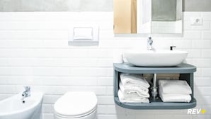 Un baño moderno con un lavabo blanco, un bidé, un inodoro y un perchero para toallas.