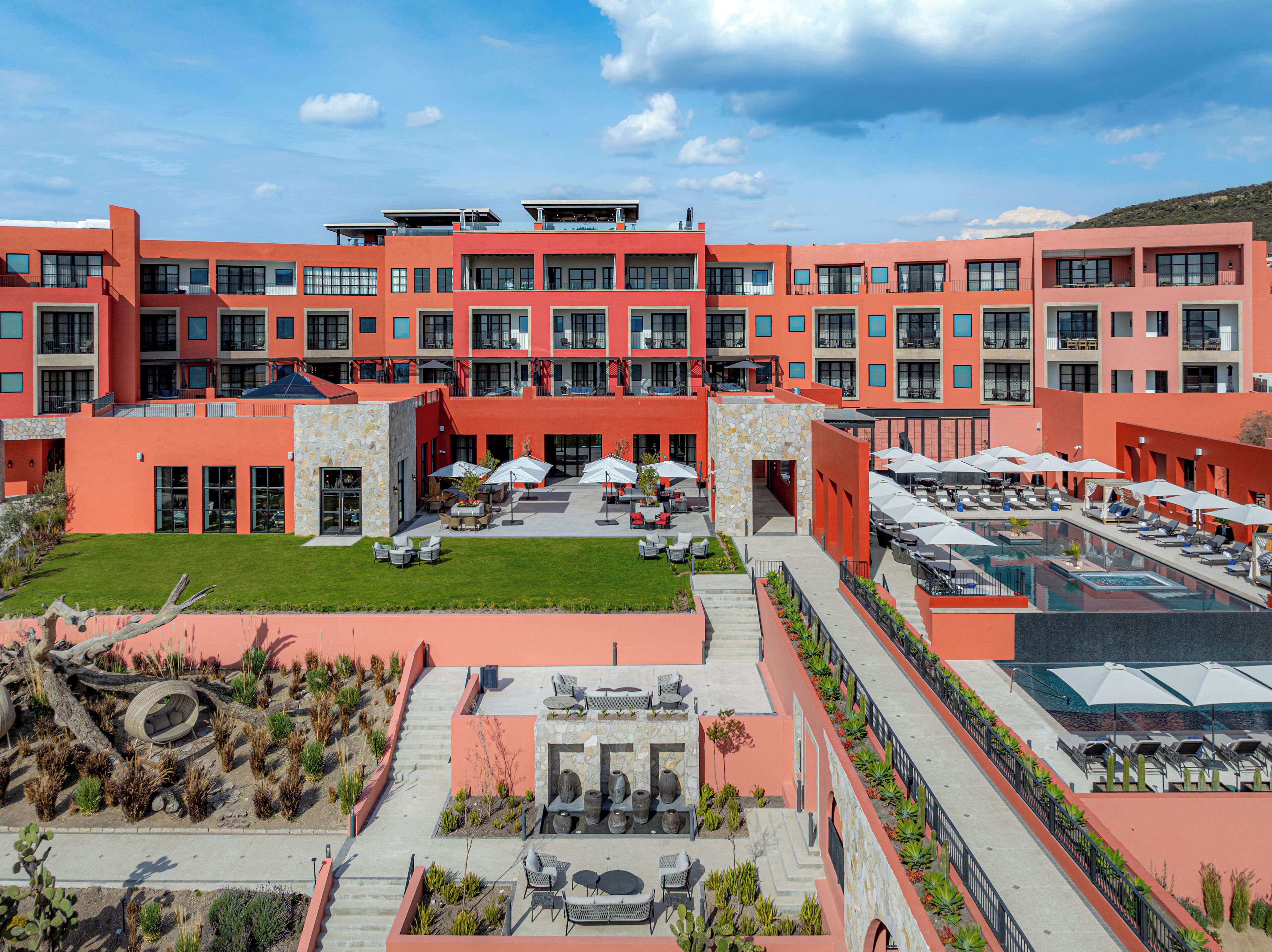 A modern building with multiple balconies and a rooftop pool area.