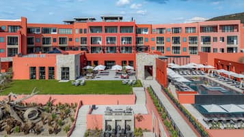Un edificio moderno con varios balcones y una zona de piscina en la azotea.