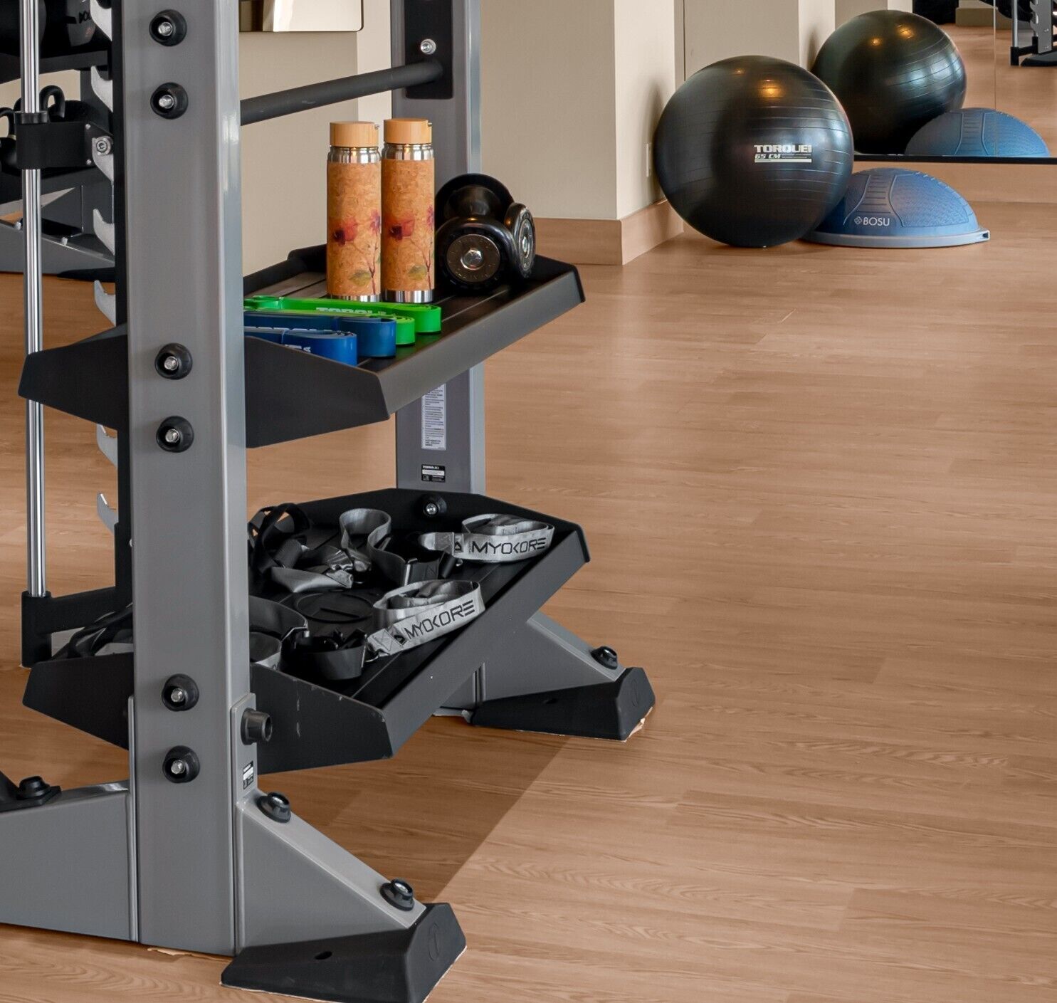 A gym with a weightlifting rack, kettlebells, exercise balls, and resistance bands.