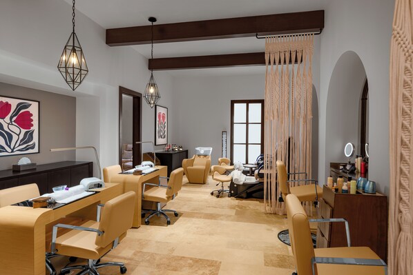 Un salón moderno con varias sillas, un mostrador de recepción y un espejo grande.
