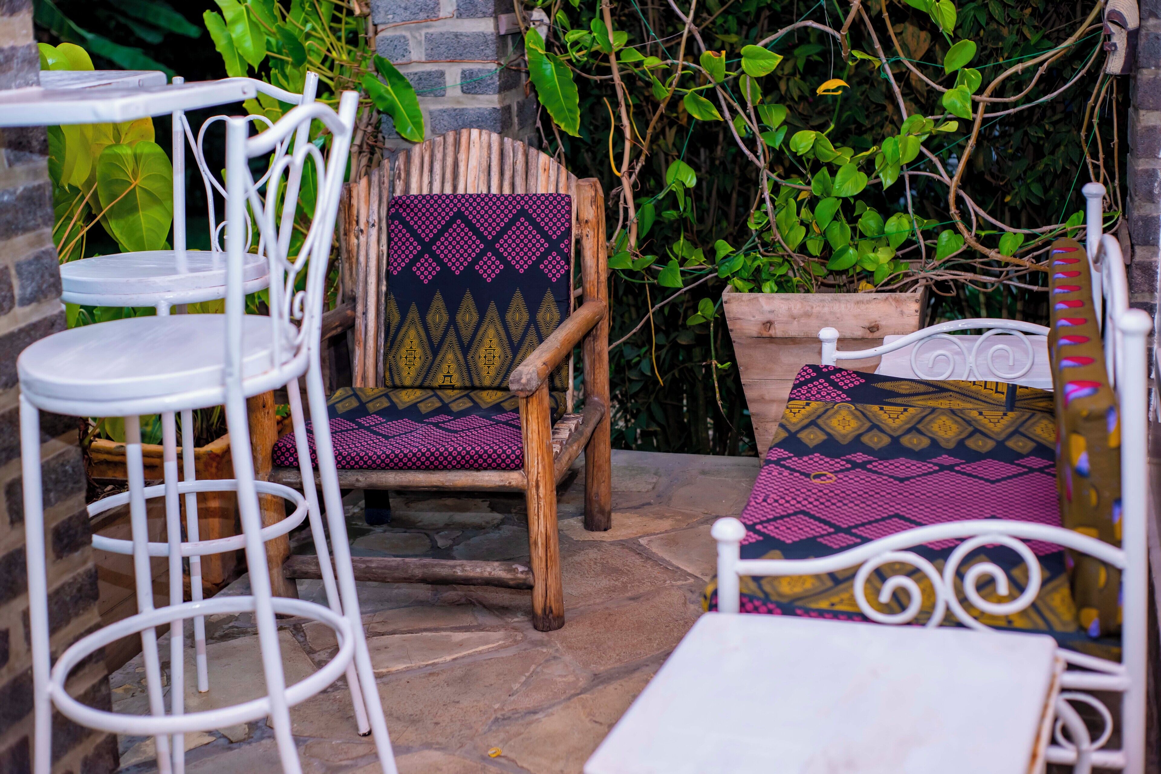 A patio area with a wooden chair and a white metal table.