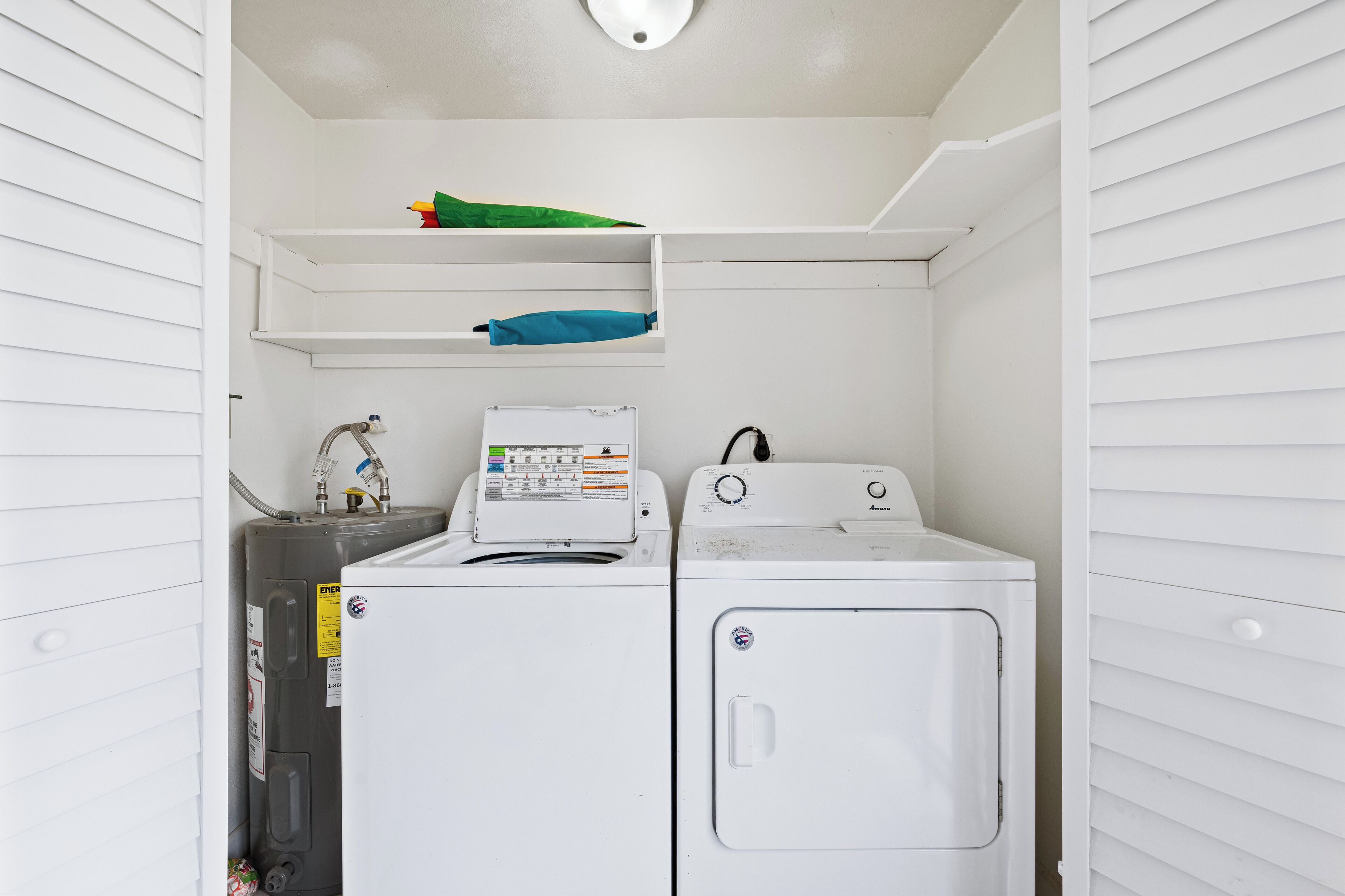 A laundry room with a washing machine, dryer, and a water heater.