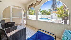 A covered patio with wicker furniture, a pool view, and a ceiling fan. - Beautiful Two Bedroom/ Two Bath Bianco Sands, Quick Walk to Beach! (Siesta Key)