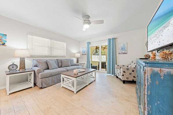A living room with a sofa, coffee table, and a television.