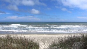 Ein Strand mit Wellen und blauem Himmel.