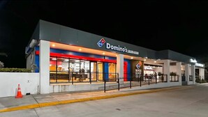 A Domino's Pizza restaurant at night with a modern facade and large windows. - WE Hotel - La Lima (La Lima)
