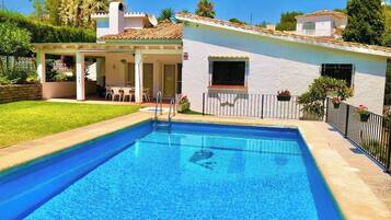A rectangular swimming pool with a clear blue water surface, surrounded by a paved deck.