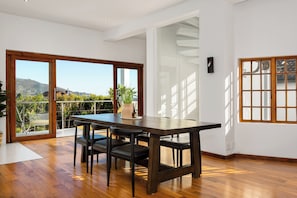 Enjoy meals with family and friends at the dining table, which seats four, in this stylish room with a balcony offering a hilly view.
