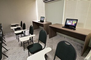 A conference room with a long table, several chairs, and two laptops on desks. - Domus Cidade Nobre (Ipatinga)