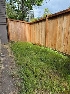 Surrounded by lush greenery, this property features a charming wooden fence.
