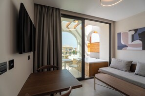 A modern room with a dining table, a sofa, a TV, and a sliding glass door leading to an outdoor area.