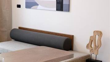 Una habitación moderna con una mesa de comedor de madera, un banco con cojines y una obra de arte abstracta colgada en la pared.
