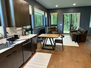 Una cocina moderna con comedor, ventanas amplias y vistas al exterior.