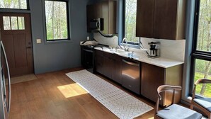 Una cocina moderna con armarios oscuros, un refrigerador de acero inoxidable y un microondas integrado.