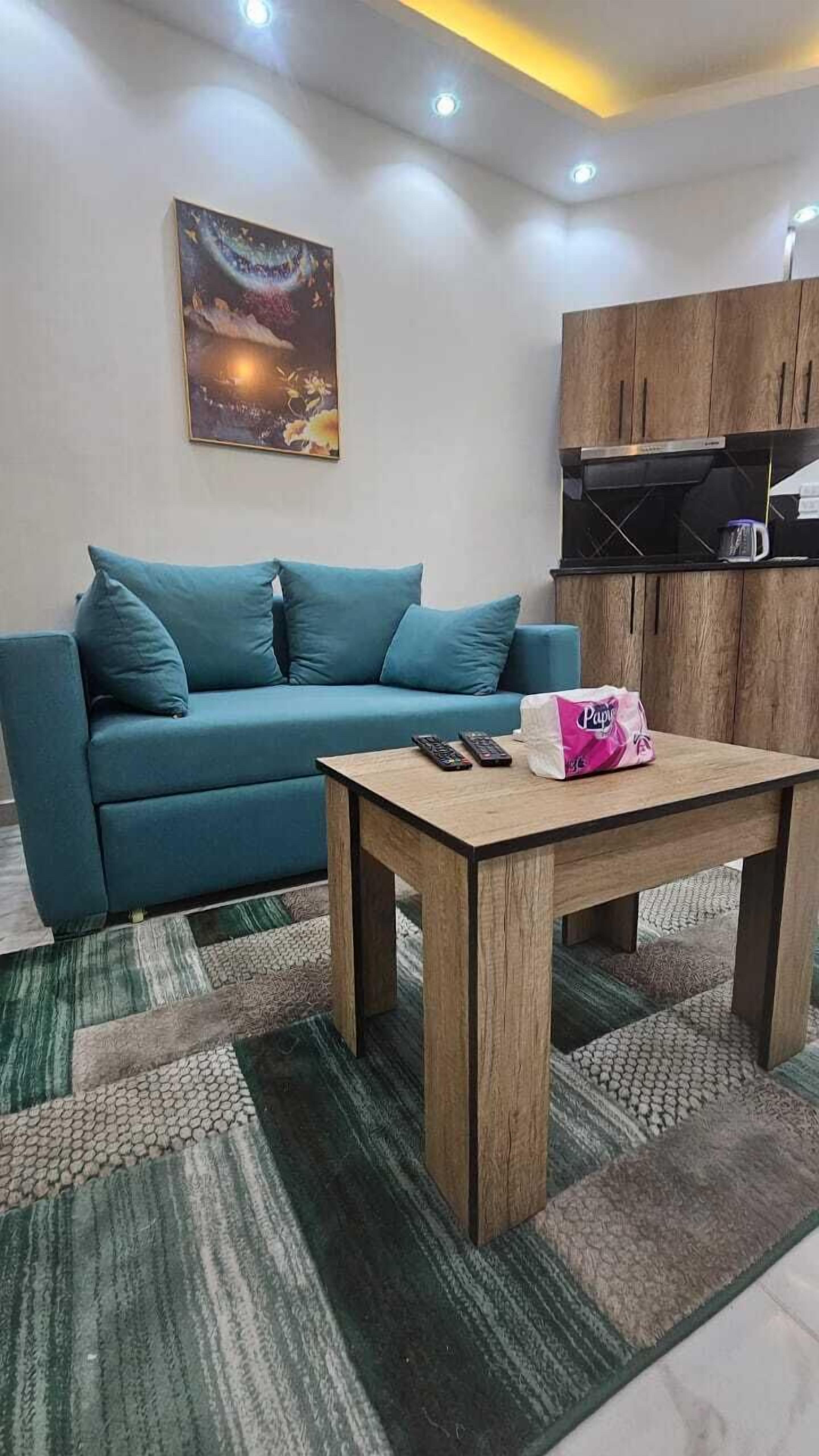 Una sala de estar con un sofá, una mesa de centro y un cuadro en la pared.