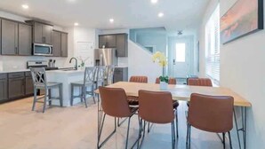 A modern kitchen with grey cabinets, a microwave, and a stainless steel refrigerator. - 4BR/3.5BH Private Pool: 5M Airport, F1 & 2-Story (Austin)