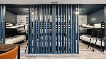 A compact room with bunk beds, a wooden table, and a chair.