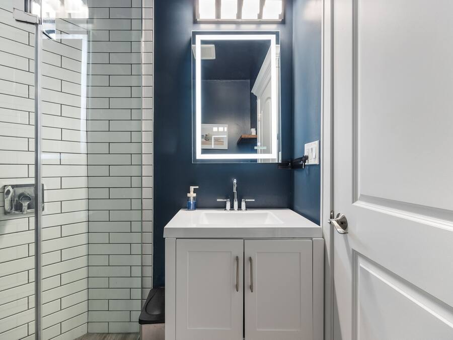 A bathroom with a white sink, a mirror, and a shower area.